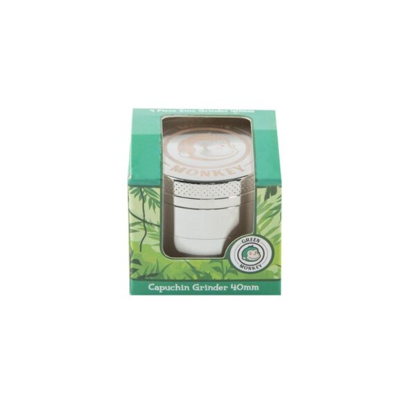 A 40mm capuchin grinder by Green Monkey, shown inside its green and white cardboard packaging box with a clear window.