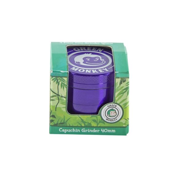 A 40mm Green Monkey capuchin grinder in metallic purple, shown inside its green retail packaging box with a clear window.