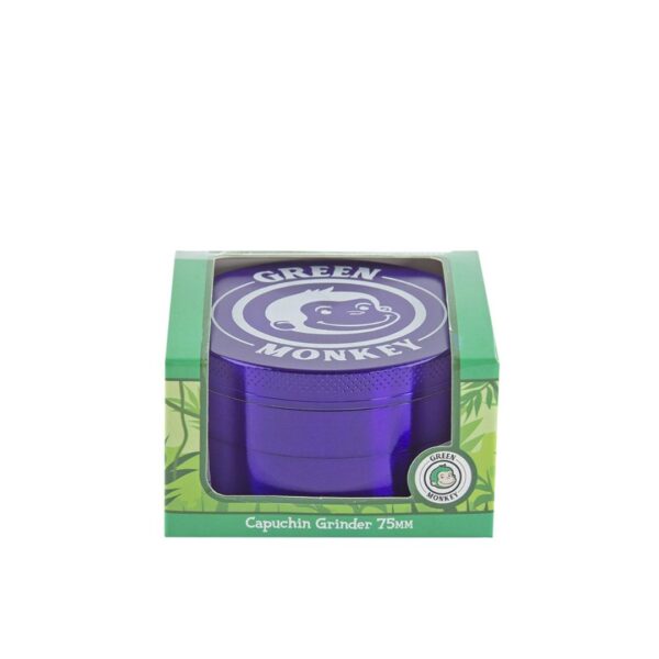 A 75mm Green Monkey capuchin grinder in purple, shown inside its green retail packaging box with a clear window.