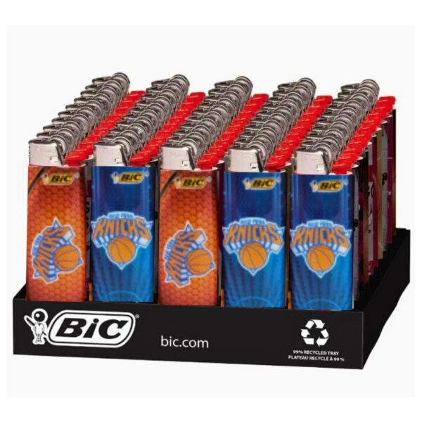 A BIC display tray holding multiple BIC lighter-style plastic containers arranged in rows. The front row includes orange and blue New York Knicks designs, with red and blue designs behind them.