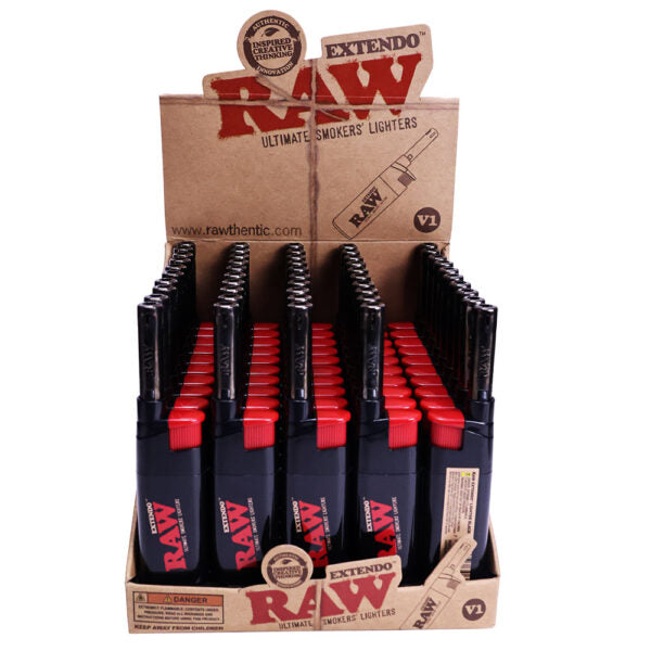 A RAW brand retail display box filled with multiple black and red RAW Ultimate Smokers Lighters, photographed on a plain white background.