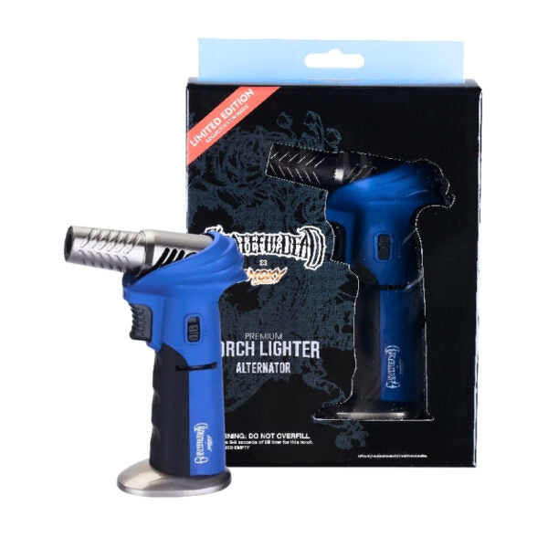 A blue and black torch lighter shown in front of its retail packaging box. The lighter has a metallic silver nozzle and base, with the brand name 'Smoxy' visible on both the product and the box.
