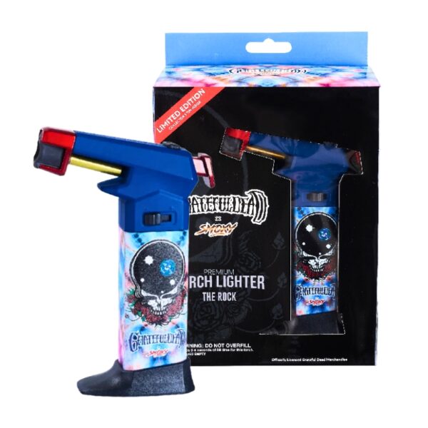A blue and black torch lighter with a Grateful Dead skull graphic, shown next to its retail packaging box. The packaging features a black background with a blue top header and a red 'Limited Edition' banner.