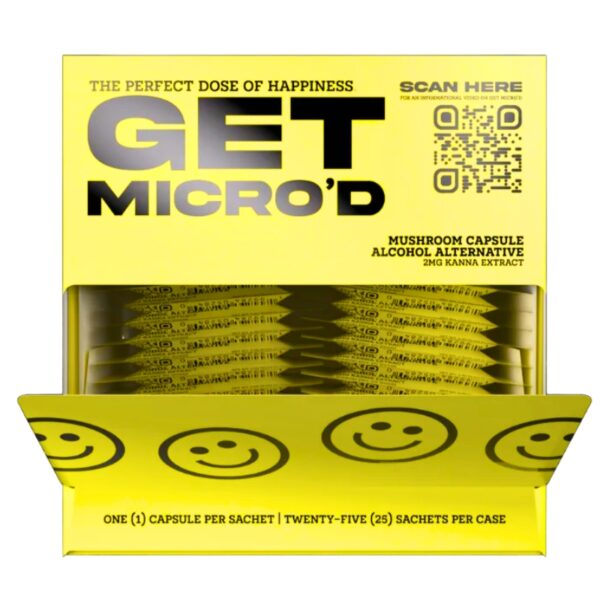 A bright yellow package of Get Micro'd Mushroom Capsule Alternative, showing a QR code, product text, and a row of individual capsule sachets inside a clear window, with a yellow lid decorated with smiley faces.