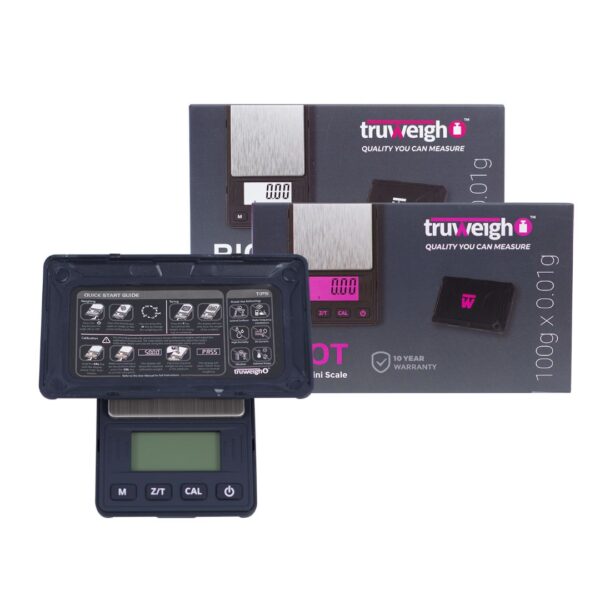 A digital pocket scale in the foreground with its packaging boxes behind it on a plain white background. The scale is dark gray/black with a small green display screen and front control buttons.