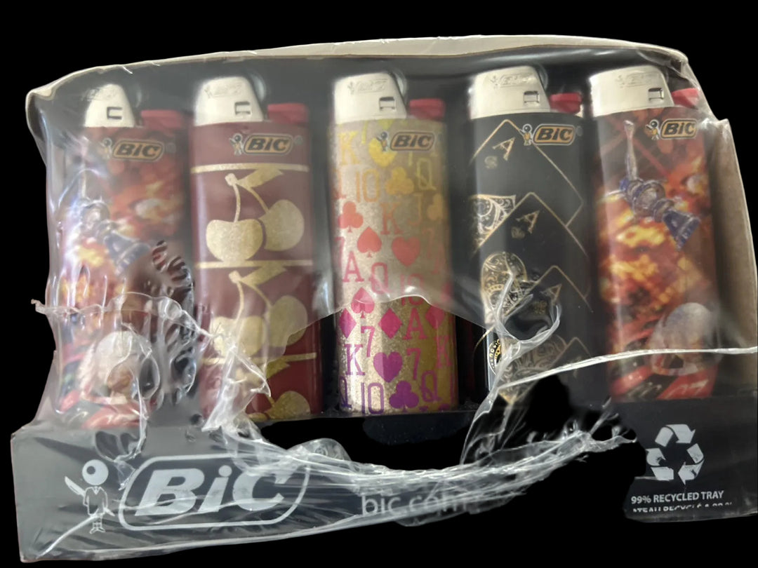 A five-pack of BIC lighters in a clear plastic tray with a printed base, wrapped in clear plastic. The lighters feature various designs including cherry patterns, hearts, and playing card suits.