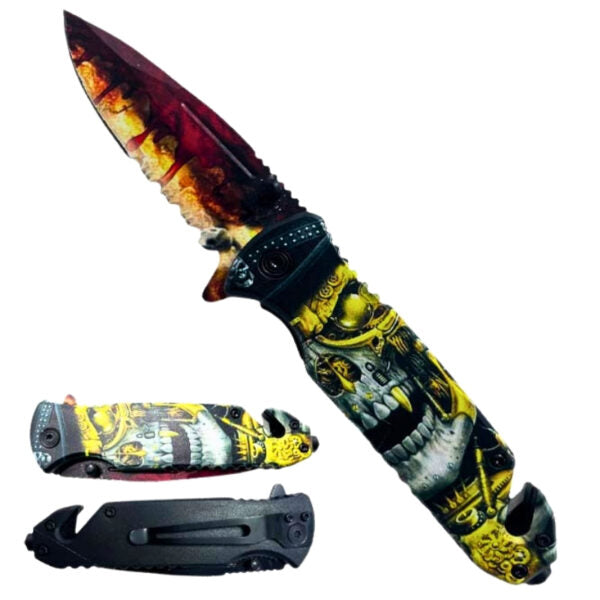 A folding pocket knife shown open and closed on a plain white background. The knife features a black handle with a detailed yellow, gray, and white skull graphic, and a blade with a red, orange, and yellow flame pattern.