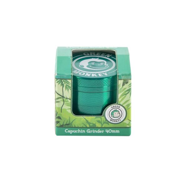 A green metal capuchin grinder in its original packaging, featuring a green and white box with a clear window showing the grinder inside. The packaging has a green monkey logo and the text 'Green Monkey' and 'Capuchin Grinder 40mm'.