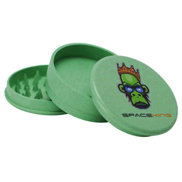 A green metal herb grinder with a matching lid, featuring a cartoon monkey wearing a crown and the brand name 'SPACEKINGS' printed on the lid, set against a plain white background.