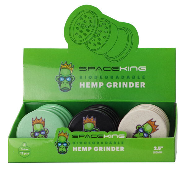 A green retail display box containing three round biodegradable hemp grinders from Space King, with the brand name and cartoon character printed on the packaging.