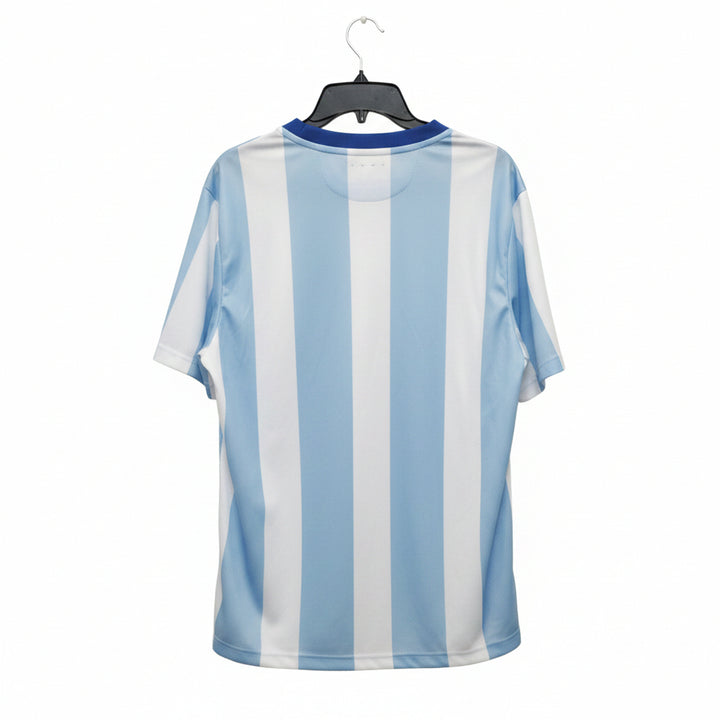 A light blue and white vertically striped short-sleeve t-shirt hanging on a black hanger against a wooden door background.