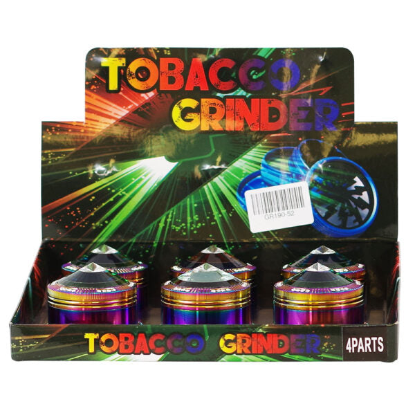 A retail display box containing four metallic tobacco grinder devices with holographic rainbow finishes. The display features colorful 'TOBACCO GRINDER' text and a barcode sticker on a white background.