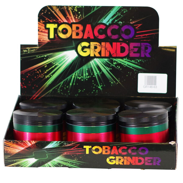 A retail display box containing six metal tobacco grinders. The grinders have a metallic red body with a green band and a black lid.