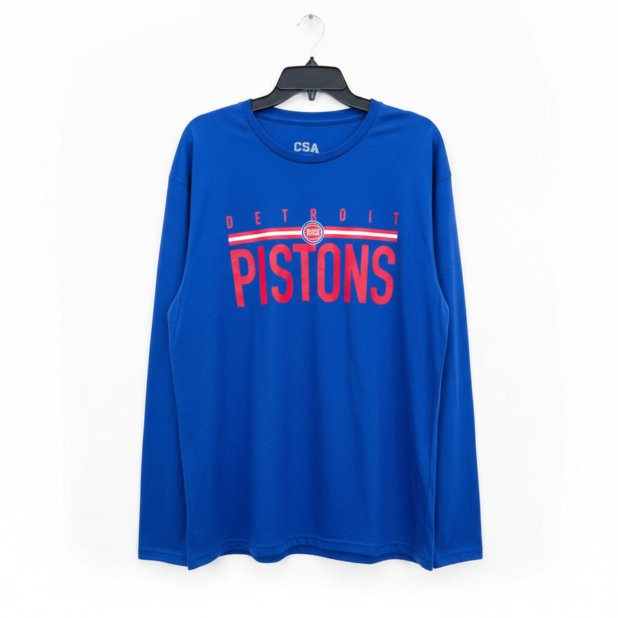 A royal blue long-sleeve Detroit Pistons t-shirt hanging on a black hanger against a wooden door background. The shirt features 'DETROIT PISTONS' printed in red across the chest with a white and red stripe design, and 'CSA' printed in white on the inside collar.
