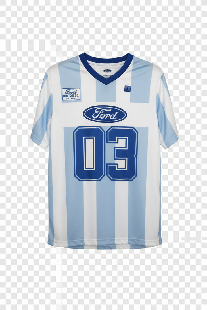 A short-sleeve Ford Racing jersey with light blue and white vertical stripes, featuring a large blue '03' on the front, a Ford oval logo, and a Ford Motor Co. patch on the chest, hanging on a hanger against a wood-paneled wall.