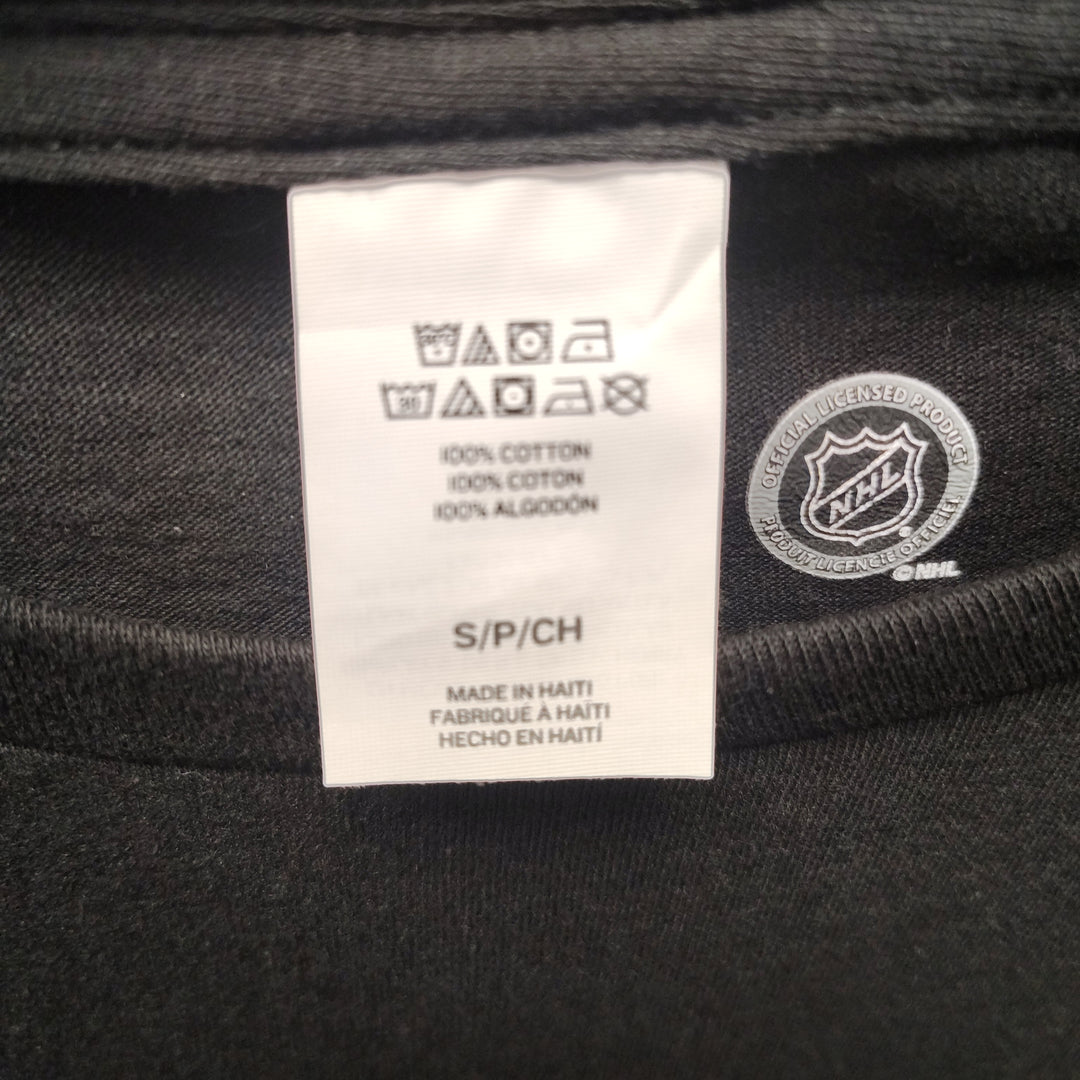 Care label showing 100% cotton, size S, Made in Haiti, Official NHL Licensed Product