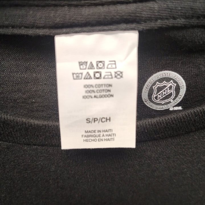 Care label showing 100% cotton, size S, Made in Haiti, Official NHL Licensed Product