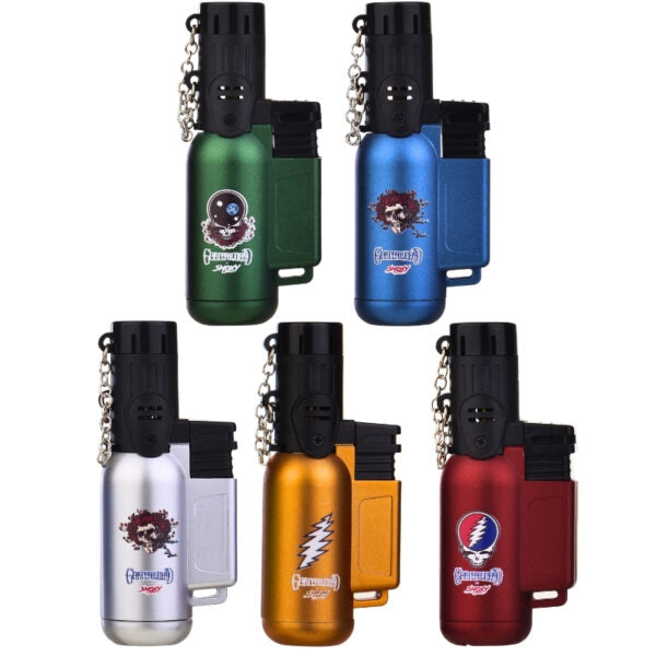 Five small metal lighter-style keychain tools shown on a white background, each with a black top, silver keychain chain, and a different body color: green, blue, silver, orange, and red. Each body has a printed cartoon face graphic and the word 'Grateful'  near the bottom.