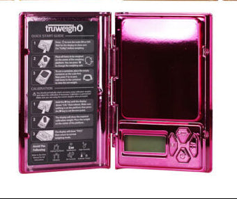 Four open digital pocket scales arranged in a 2x2 grid on a white background, showing different metallic finishes: gold, iridescent gold/black, iridescent green/black, and hot pink. The scales are branded 'trumeigho' on the interior display backs.