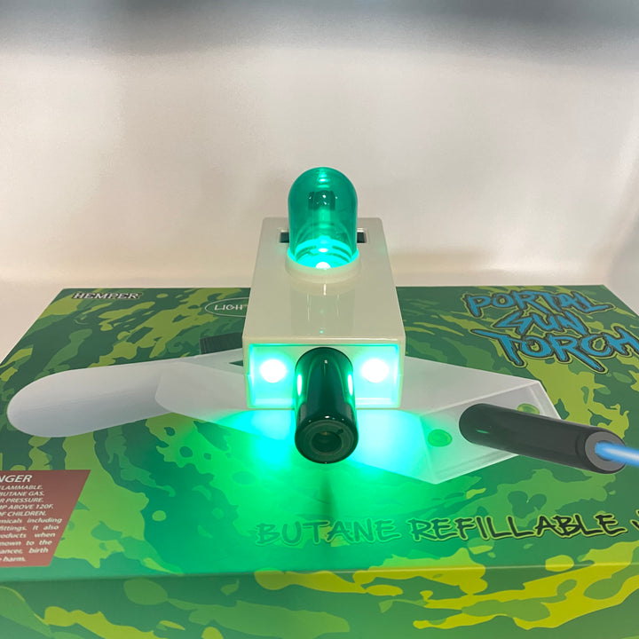 Hemper Portal Gun jet torch with glowing green LED lights and a plasma core, resting on its branded packaging.