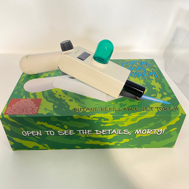 Off-white Hemper Portal Gun jet torch with a green dome and blue flame, resting on its themed green packaging box.