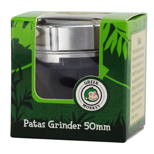 Patas Grinder 50mm in its original green branded packaging box, featuring a clear window showing the dark grinder body and silver metal lid.