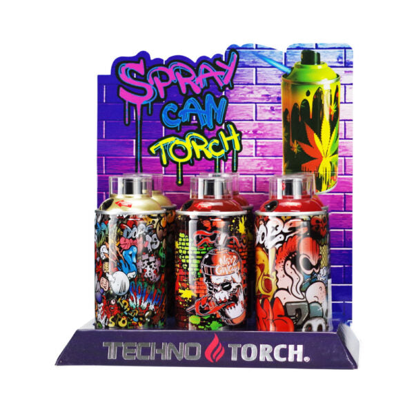Three Techno Torch lighter spray cans displayed on a branded purple stand against a purple brick-pattern backdrop. The cans feature colorful graffiti-style artwork, and the sign behind reads 'Spray Can Torch.