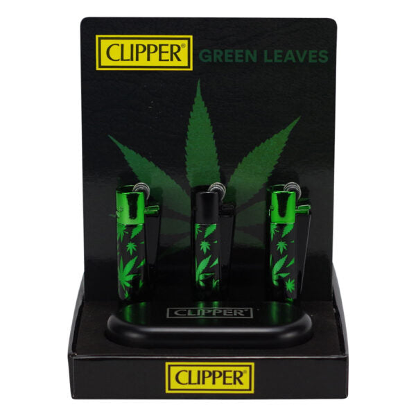 Three green and black Clipper lighter-shaped accessories displayed in a black retail stand with 'CLIPPER GREEN LEAVES' branding and a large leaf graphic on a white background.