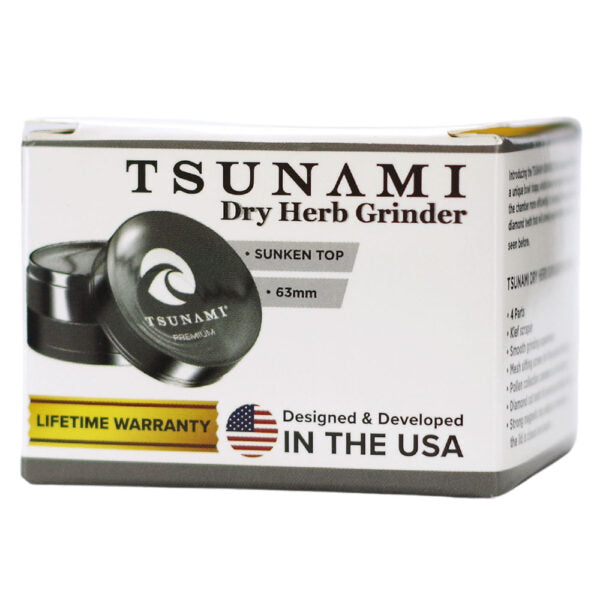 Tsunami Dry Herb Grinder packaging box, featuring a white box with black text, a graphic of the black metal grinder, and a yellow 'Lifetime Warranty' banner.