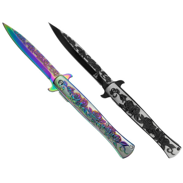 Two folding pocket knives with ornate rose engravings, one showing a vibrant iridescent rainbow blade and the other showing a black and silver engraved blade, set against a plain white background.